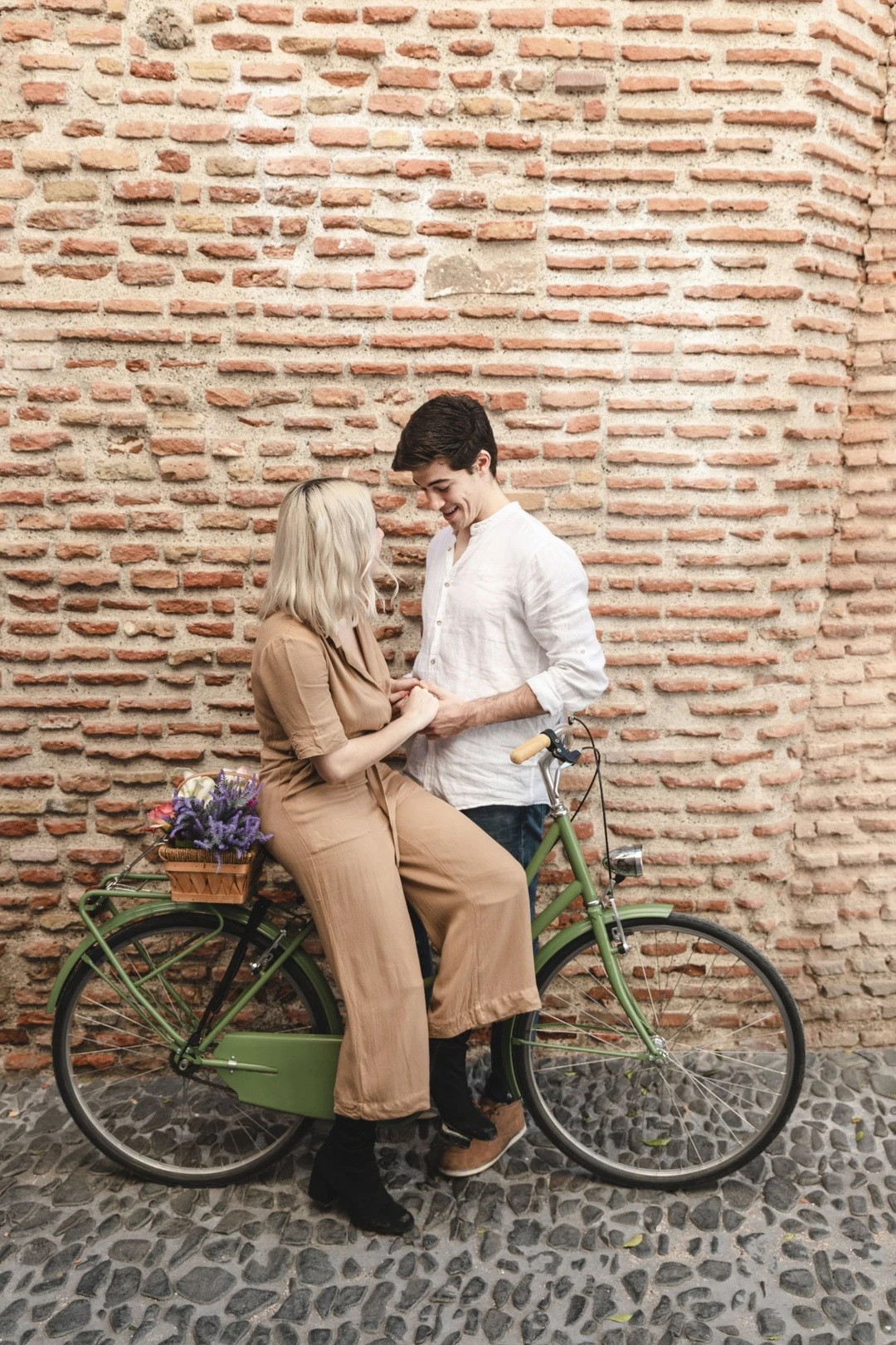 couple-posing-against-brick-wall-with-bicycle.jpg